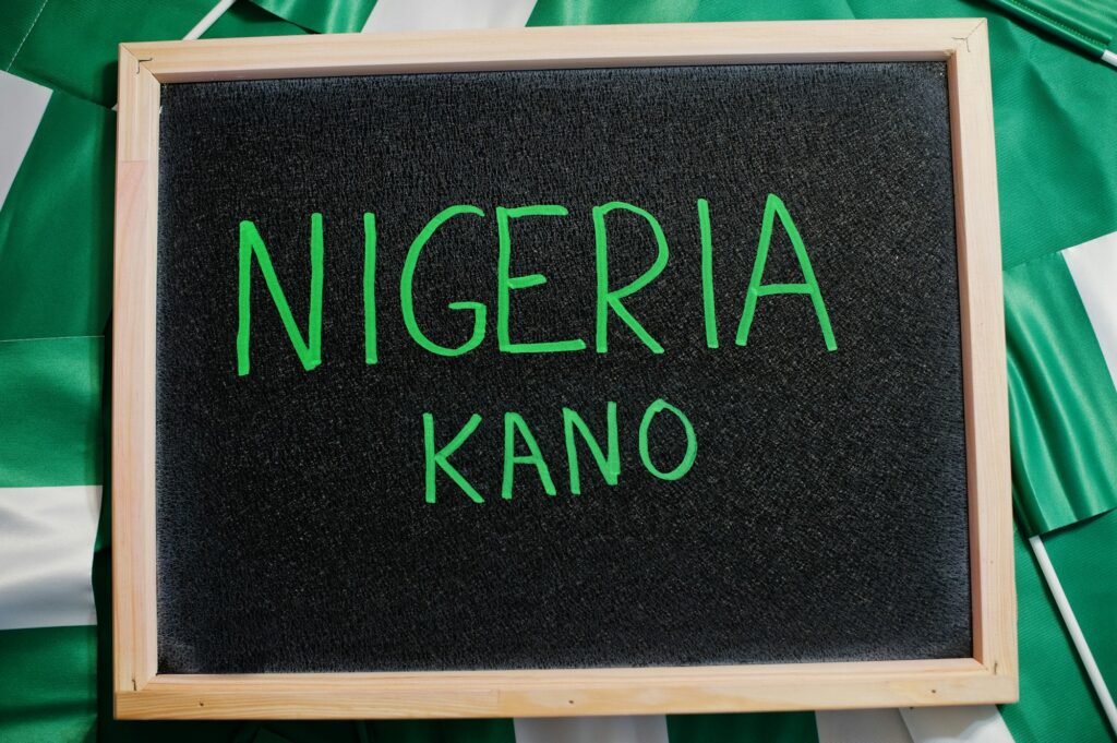 Happy independence day of Nigeria, Kano. Text on board with nigerian flags.