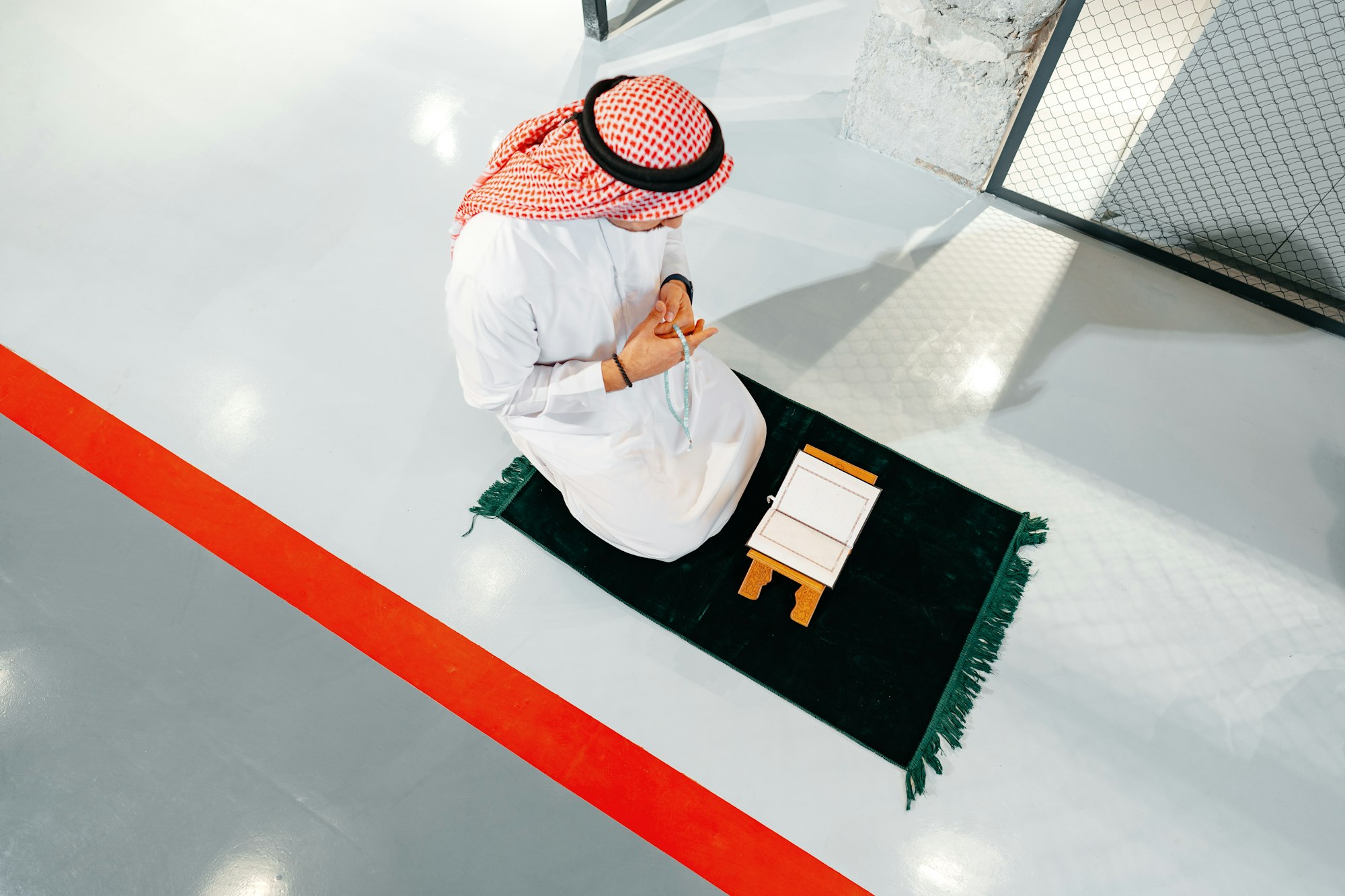 Young arab muslim man reading the holy Quran in the office